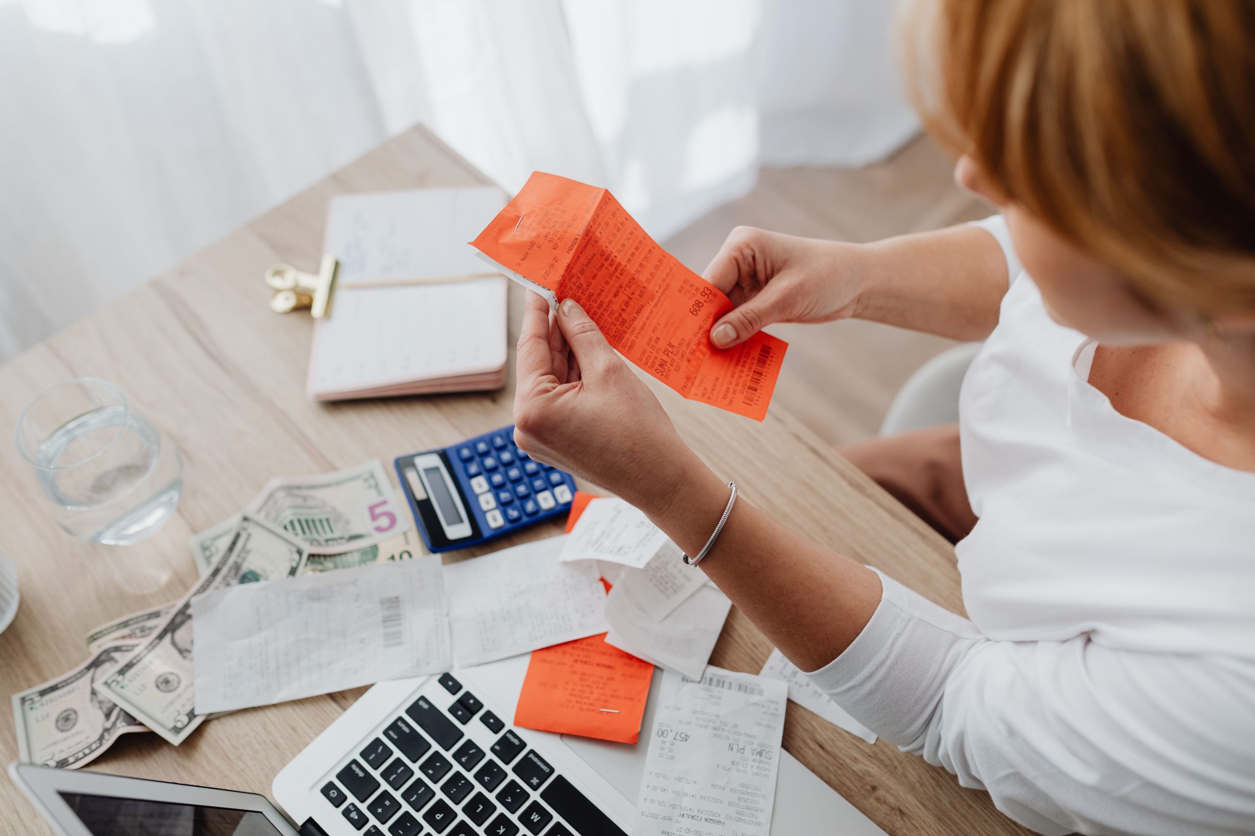 Femme utilisant une calculatrice avec des recus