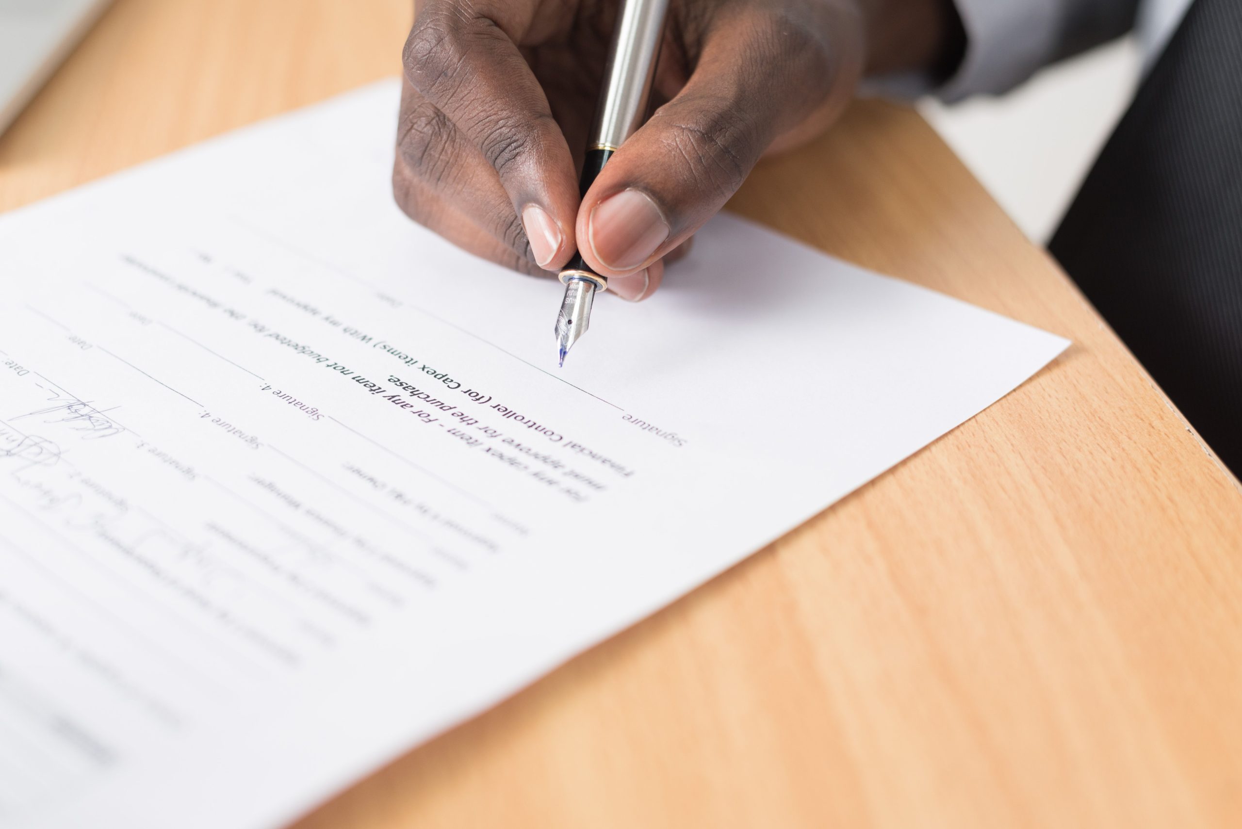 Main tenant un stylo signant un document