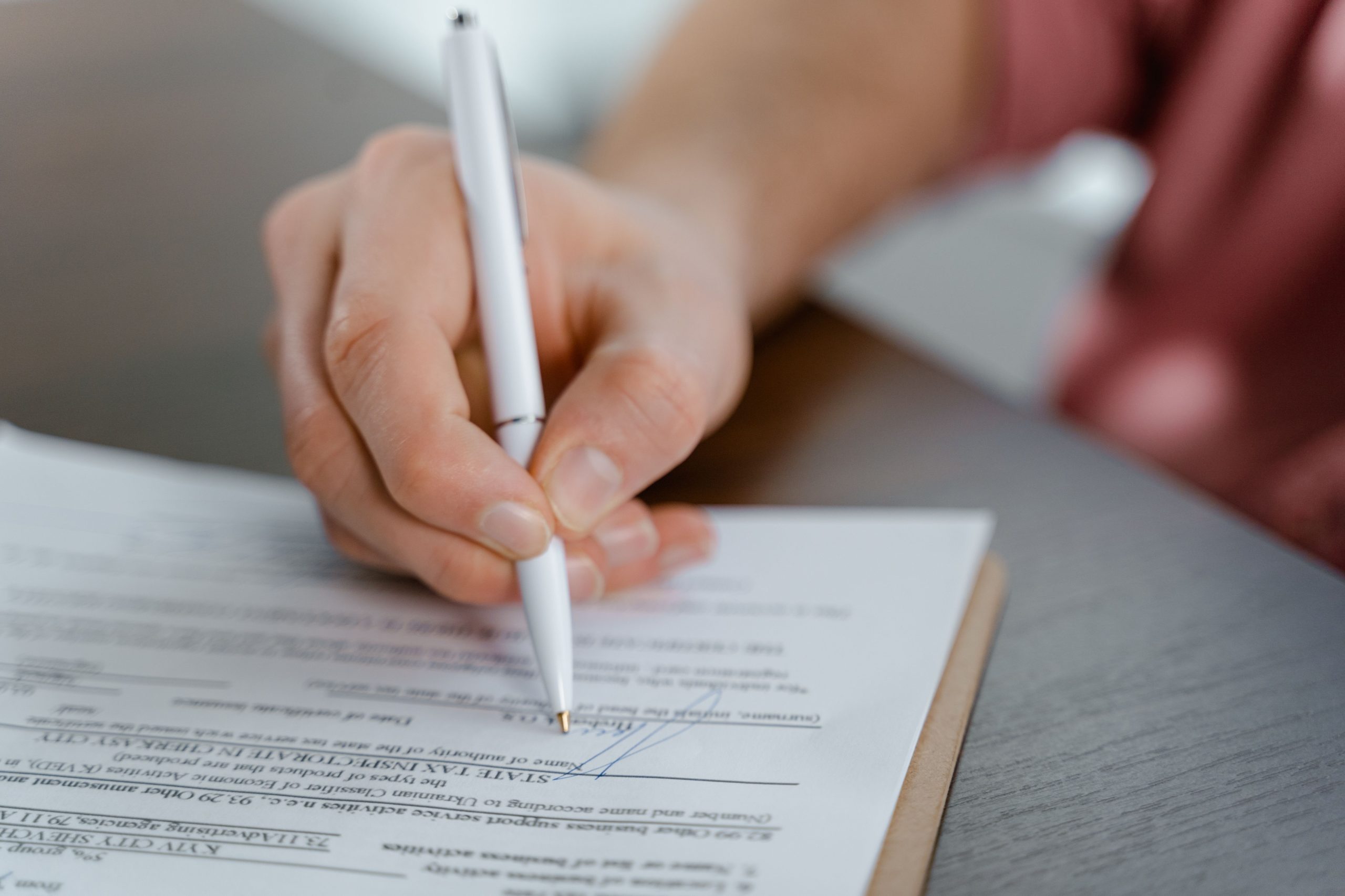 Main écrivant une signature sur un acte officiel